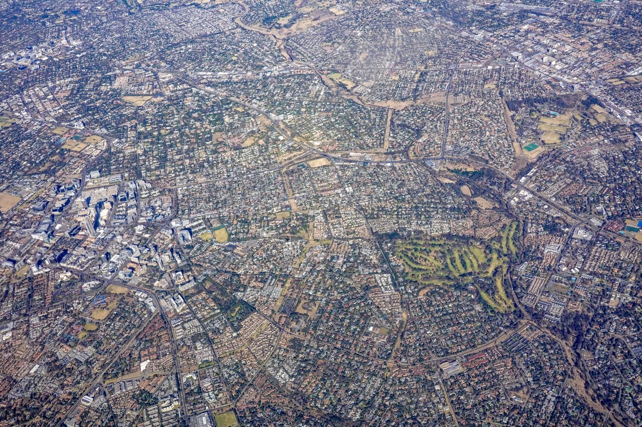 Home High altitude aerial photo showing dense urban cityscape with roads and green parks.
